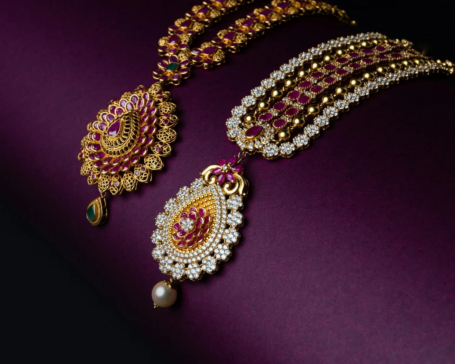 Gem-set gold earrings photographed on purple velvet